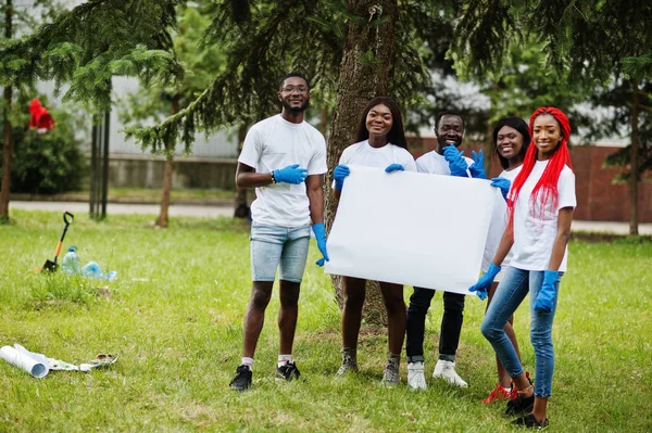 Μια ομάδα από χαρούμενους Αφρικανούς εθελοντές κρατούν κενή κενή σανίδα στο πάρκο — Φωτογραφία Αρχείου
