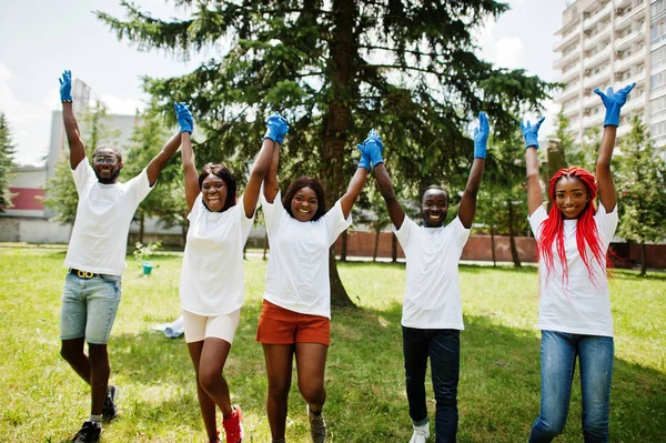 Μια ομάδα από χαρούμενους Αφρικανούς εθελοντές κρατούν τα χέρια μαζί στο πάρκο. A — Φωτογραφία Αρχείου