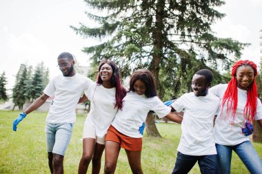 Grup mutlu Afrikalı gönüllüler parkta birlikte kucaklıyor. Afrika vol