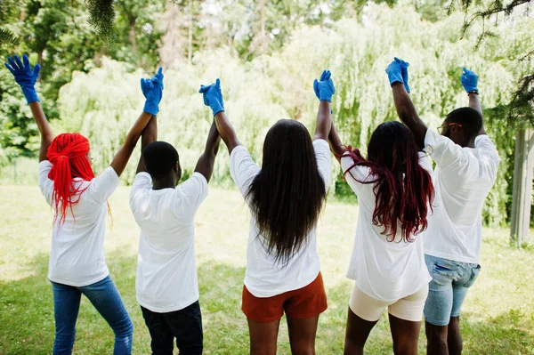 Bak i gruppen Happy African volontärer hålla händerna tillsammans i PA — Stockfoto