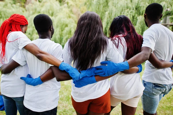 Kembali ke kelompok relawan african yang bahagia berpelukan bersama di taman. Af — Stok Foto