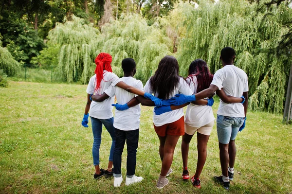 Bak i grupp lyckliga afrikanska volontärer kramar tillsammans i parken. Af — Stockfoto