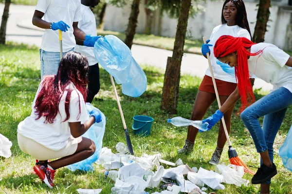 Group of happy african volunteers with garbage bags cleaning are