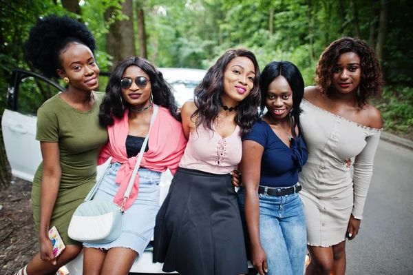 Grupo de cinco meninas americanas africanas felizes sentadas em um capuz de carro — Fotografia de Stock