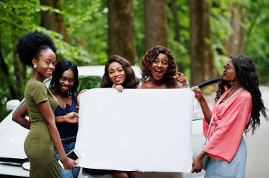 Beş mutlu Afro-Amerikan kız grubu araba karşı poz verdi ve