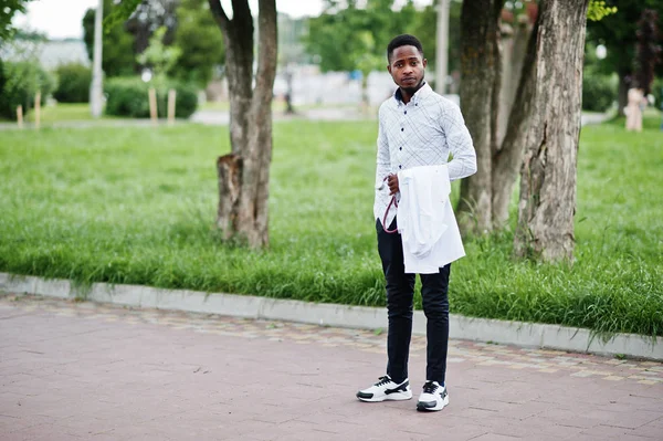Fiatal afroamerikai férfi orvos tartsa fehér kabátot kéznél — Stock Fotó