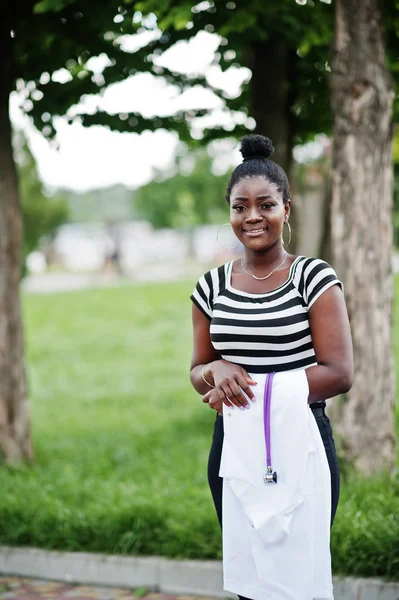 Jovem Africano americano feminino médico segurar casaco branco na mão sagacidade — Fotografia de Stock