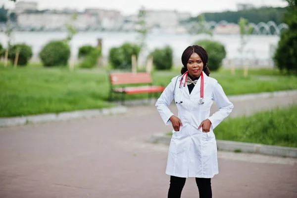 Young african american female doctor in white coat with a stetho