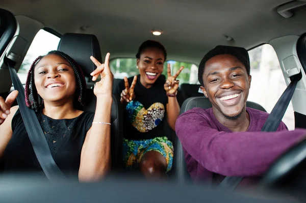 Jovens amigos africanos americanos sentados dentro de um carro . — Fotografia de Stock