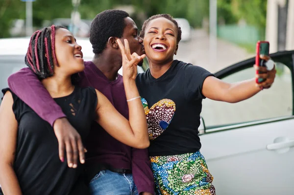 Three african american friends stay near car and making selfie o — Stock Photo, Image