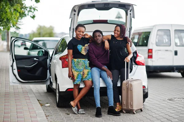 Tres amigos afroamericanos se sientan en el maletero del coche . — Foto de Stock