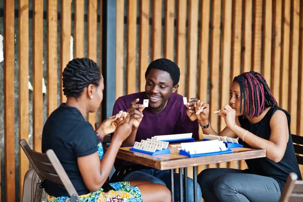 Gruppe von drei afrikanisch-amerikanischen Freunden spielt Tischspiele. — Stockfoto