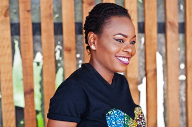 Genç Afrikalı Amerikalı kadın ahşap duvara karşı poz.