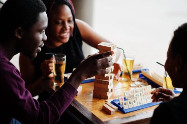 Üç Afrikalı Amerikalı arkadaş grubu masa oyunları oynar.