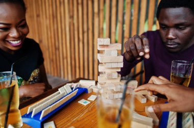Üç Afrikalı Amerikalı arkadaş grubu masa oyunları oynar.