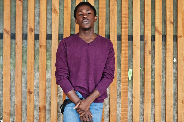 Young african american man in violet jumper posed against wooden — Stock Photo, Image