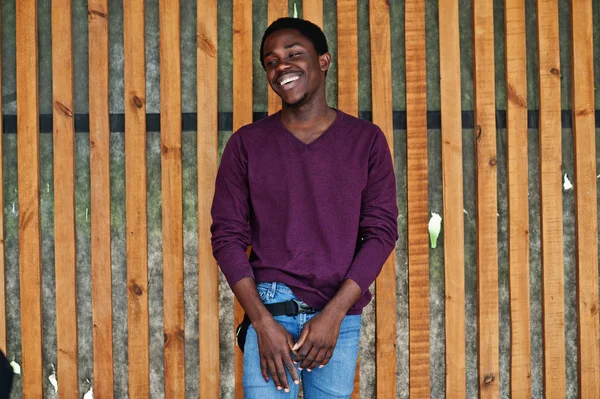 Молодой африканский американец в фиолетовом свитере позировал против дерева — стоковое фото