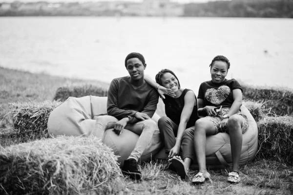 Tres amigos afroamericanos se relajan y se sientan en pufs outdoo — Foto de Stock