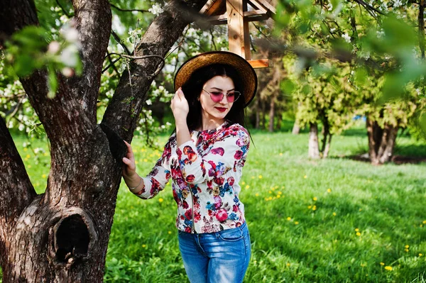 Весенний портрет брюнетки в розовых очках и шляпе на гри — стоковое фото
