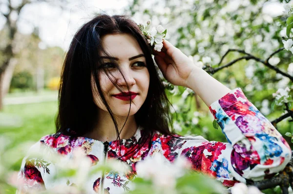 Portrait printanier de fille brune au jardin de fleurs vertes . — Photo