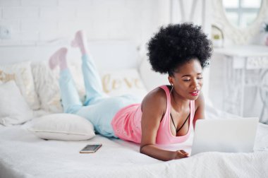 Genç afro-amerikan kadın üzerinde çalışırken yatakta yatıyor