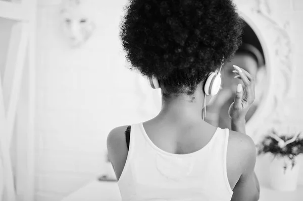 Joven mujer afroamericana mirando al espejo y escuchar mu —  Fotos de Stock