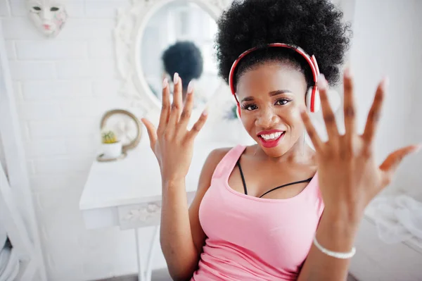 Young african american woman looking at the mirror and show her