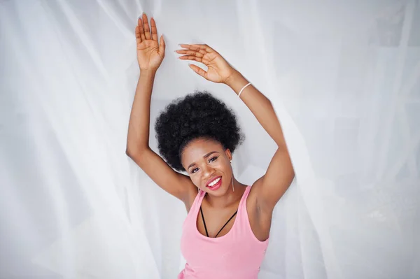 Ung afrikansk amerikansk kvinna i rosa linne mot Window iPod — Stockfoto