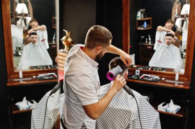 Genç adam otururken ben saç kesimi Kuaför tarafından getting sakallı