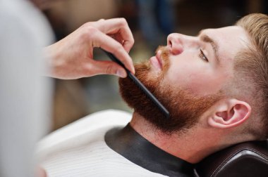 Genç adam otururken ben saç kesimi Kuaför tarafından getting sakallı