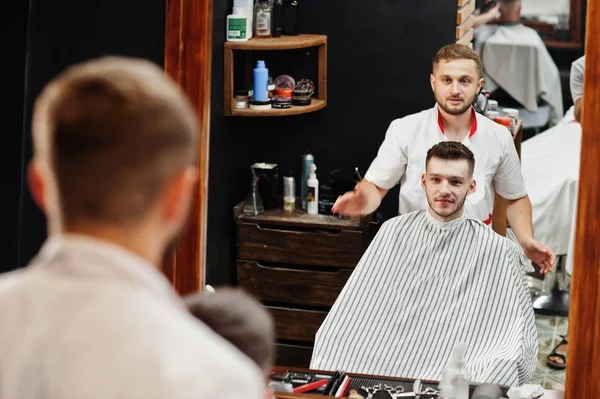 Jovem barbudo homem chegando corte de cabelo por cabeleireiro enquanto sentado eu — Fotografia de Stock