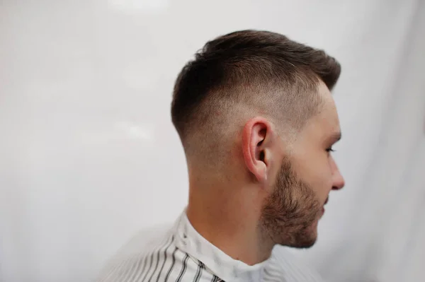 Fechar a cabeça do jovem barbudo recebendo corte de cabelo na barbearia — Fotografia de Stock