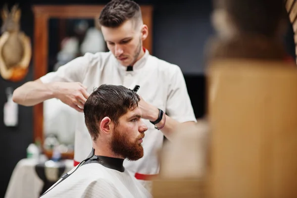 Jovem barbudo homem chegando corte de cabelo por cabeleireiro enquanto sentado eu — Fotografia de Stock