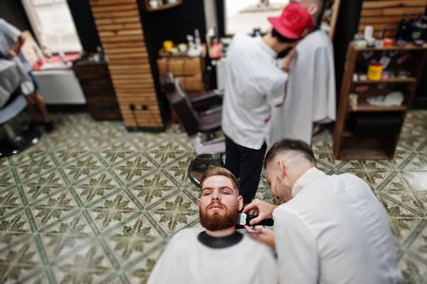 Genç adam otururken ben saç kesimi Kuaför tarafından getting sakallı — Stok fotoğraf