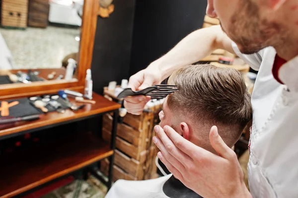 Jovem barbudo homem chegando corte de cabelo por cabeleireiro enquanto sentado eu — Fotografia de Stock