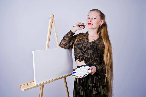 Hermosa mujer artista pintor con pinceles y lona al óleo posin — Foto de Stock