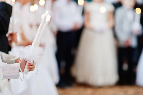Νεαρό κορίτσι σε λευκό κρατήσει κερί στο χέρι στην πρώτη θεία κοινωνία. — Φωτογραφία Αρχείου