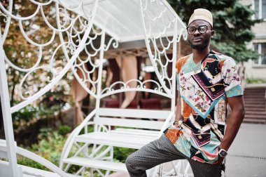 Yakışıklı afro amerikan adam geleneksel giysiler, kap ve giyiyor 