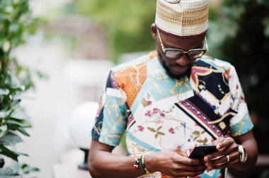 Yakışıklı afro amerikan adam geleneksel giysiler, kap ve giyiyor 