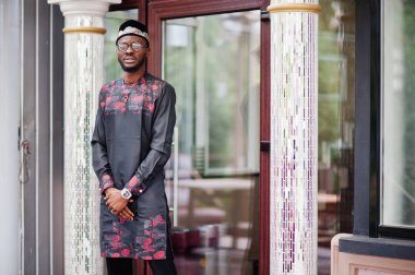 Yakışıklı afro amerikan adam geleneksel giysiler, kap ve giyiyor 