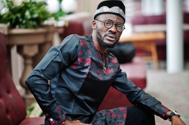 Yakışıklı afro amerikan adam geleneksel giysiler, kap ve giyiyor 