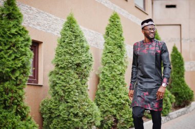 Yakışıklı afro amerikan adam geleneksel giysiler, kap ve giyiyor 