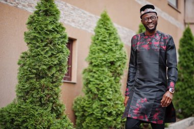 Yakışıklı afro amerikan adam geleneksel giysiler, kap ve giyiyor 