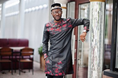 Yakışıklı afro amerikan adam geleneksel giysiler, kap ve giyiyor 