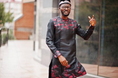 Yakışıklı afro amerikan adam geleneksel giysiler, kap ve giyiyor 