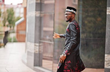 Yakışıklı afro amerikan adam geleneksel giysiler, kap ve giyiyor 