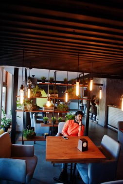 Turuncu swea gibi akıllı rahat giyim kendine güvenen genç hintli adam