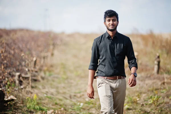 Индиец в черной рубашке и бежевых штанах позировал на поле . — стоковое фото