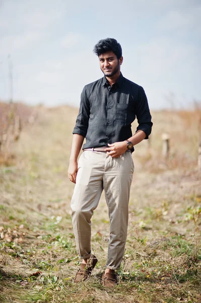 Indický muž na černé košili a béžové kalhoty na poli. — Stock fotografie