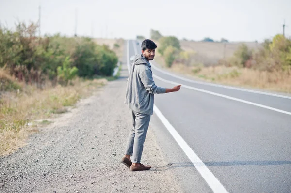 Автостопом индиец путешествует автостопом по обочине дороги на h — стоковое фото